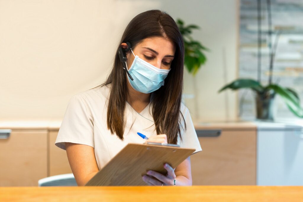 Receptionist taking notes on clipboard at medical center