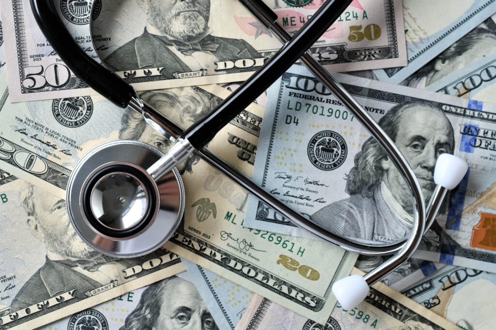 Stethoscope laying on USA money overhead - Medical costs, doctor's bills, high cost of insurance